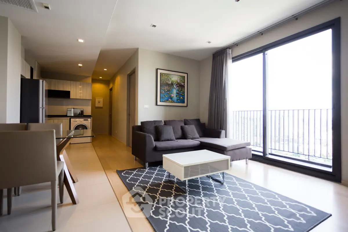 Modern living room with large windows and stylish furniture in a high-rise apartment.