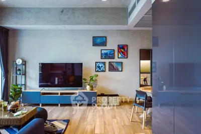 Modern living room with stylish decor and large TV, perfect for relaxation.
