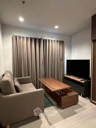 Modern living room with cozy sofa, stylish coffee table, and large TV, perfect for relaxation and entertainment.