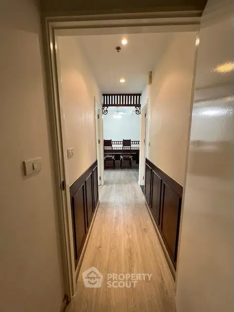 Elegant hallway leading to a stylish dining area with wooden accents.