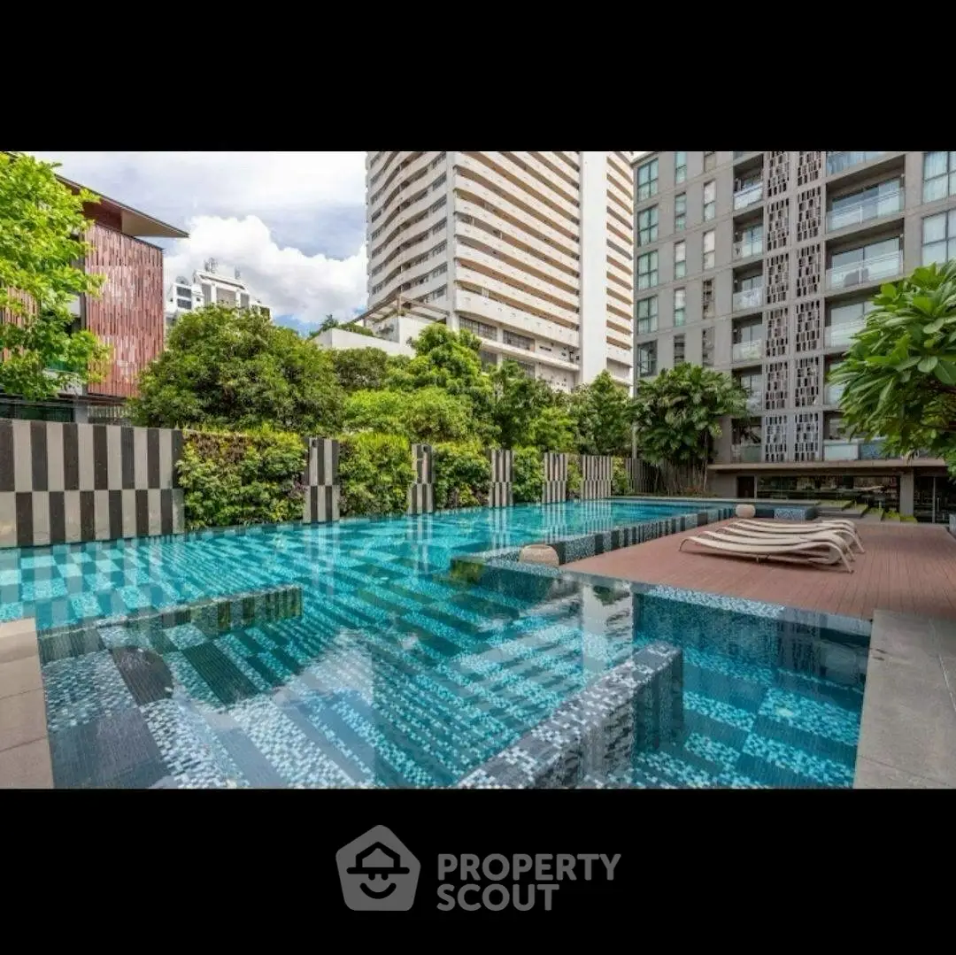Luxurious modern apartment complex with stunning outdoor pool and lush greenery.