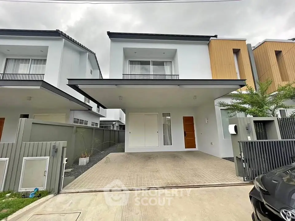 Modern two-story house with spacious driveway and sleek exterior design.