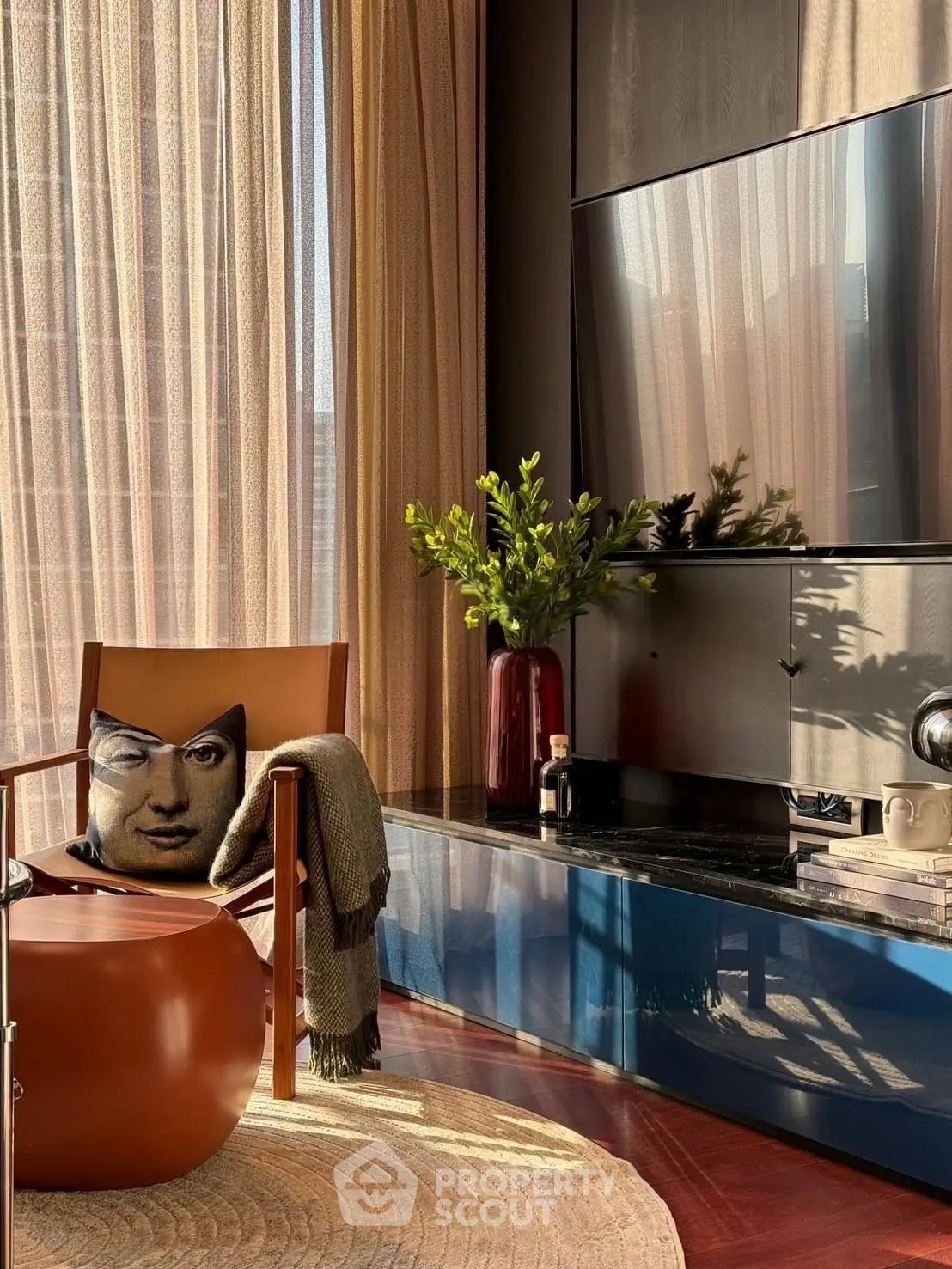 Stylish living room with modern decor, large TV, and elegant seating area bathed in natural light.