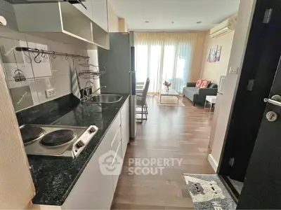 Charming open-layout kitchen and living room with modern appliances and cozy decor.