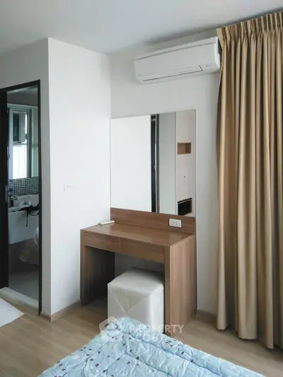 Modern bedroom with vanity, air conditioning, and partial bathroom view