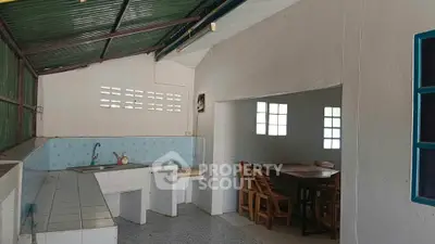 Spacious kitchen with open layout and dining area, featuring rustic charm and natural light.