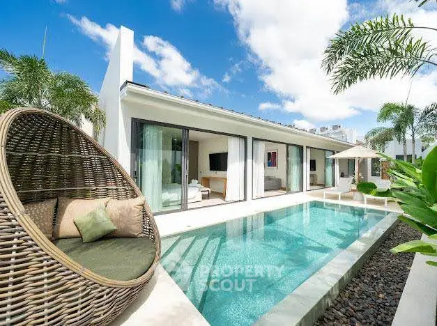 Luxurious modern villa with private pool and stylish outdoor seating in tropical setting.