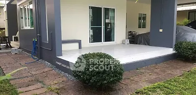 Charming patio with lush greenery and modern design, perfect for outdoor relaxation.