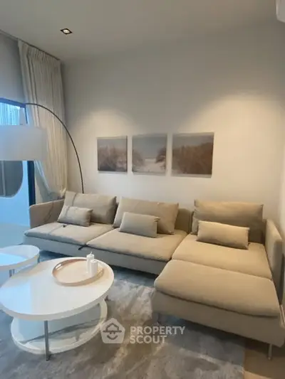 Modern living room with beige sectional sofa, stylish decor, and elegant lighting in a cozy setting.