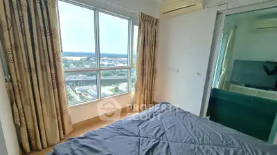 Bright bedroom with large window offering stunning city view, featuring modern decor and air conditioning.