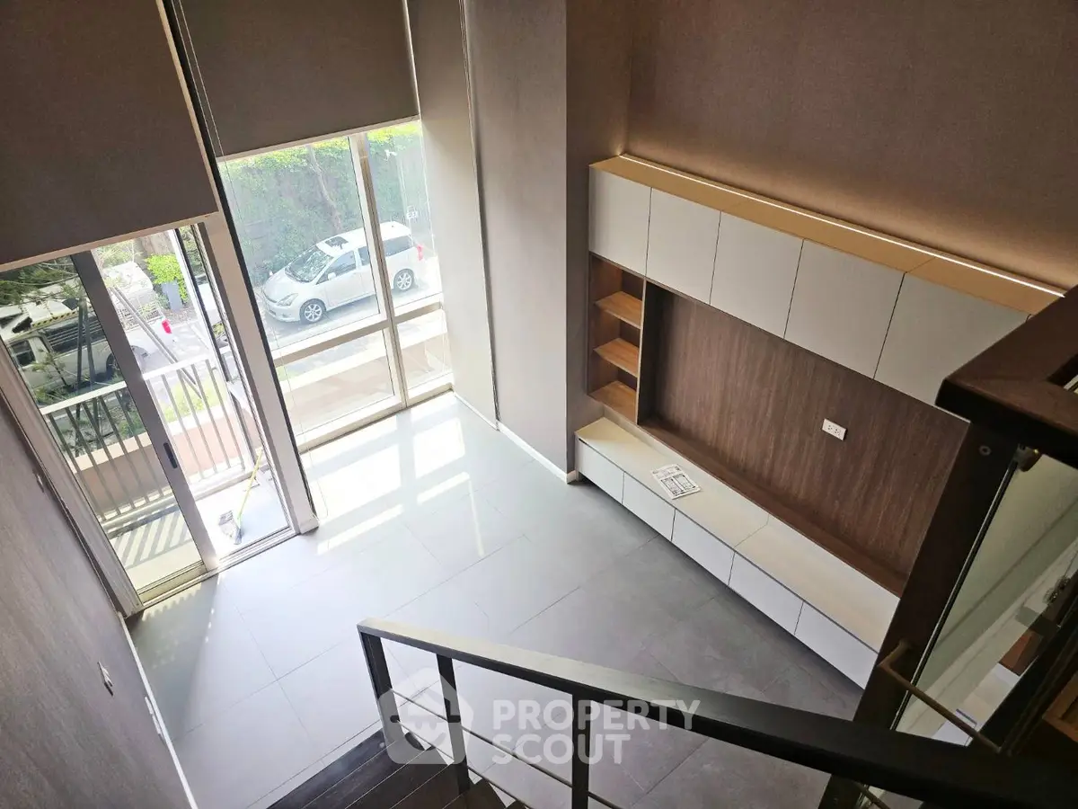 Modern duplex interior with large windows and sleek built-in storage