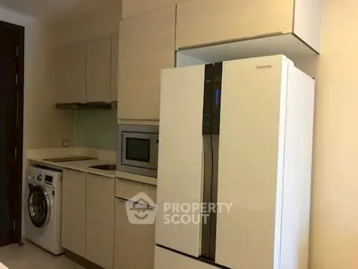 Modern kitchen with sleek appliances including fridge, oven, and washing machine.