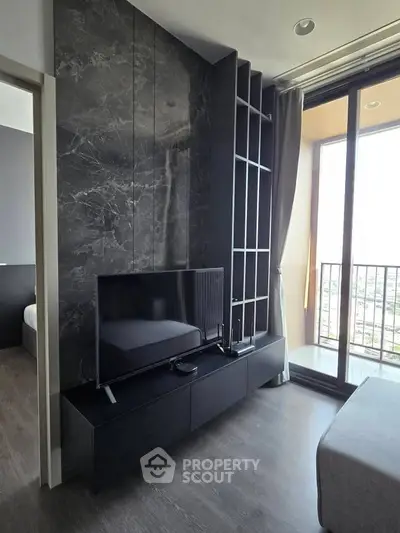 Modern living room with sleek black TV stand and floor-to-ceiling windows offering city views.