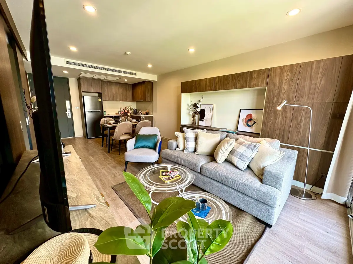 Modern open-layout living room with stylish decor and kitchen area, perfect for urban living.