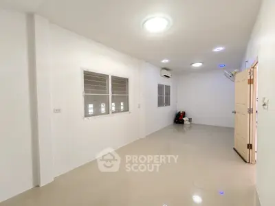 Spacious empty room with tiled flooring and bright lighting, ideal for customization.