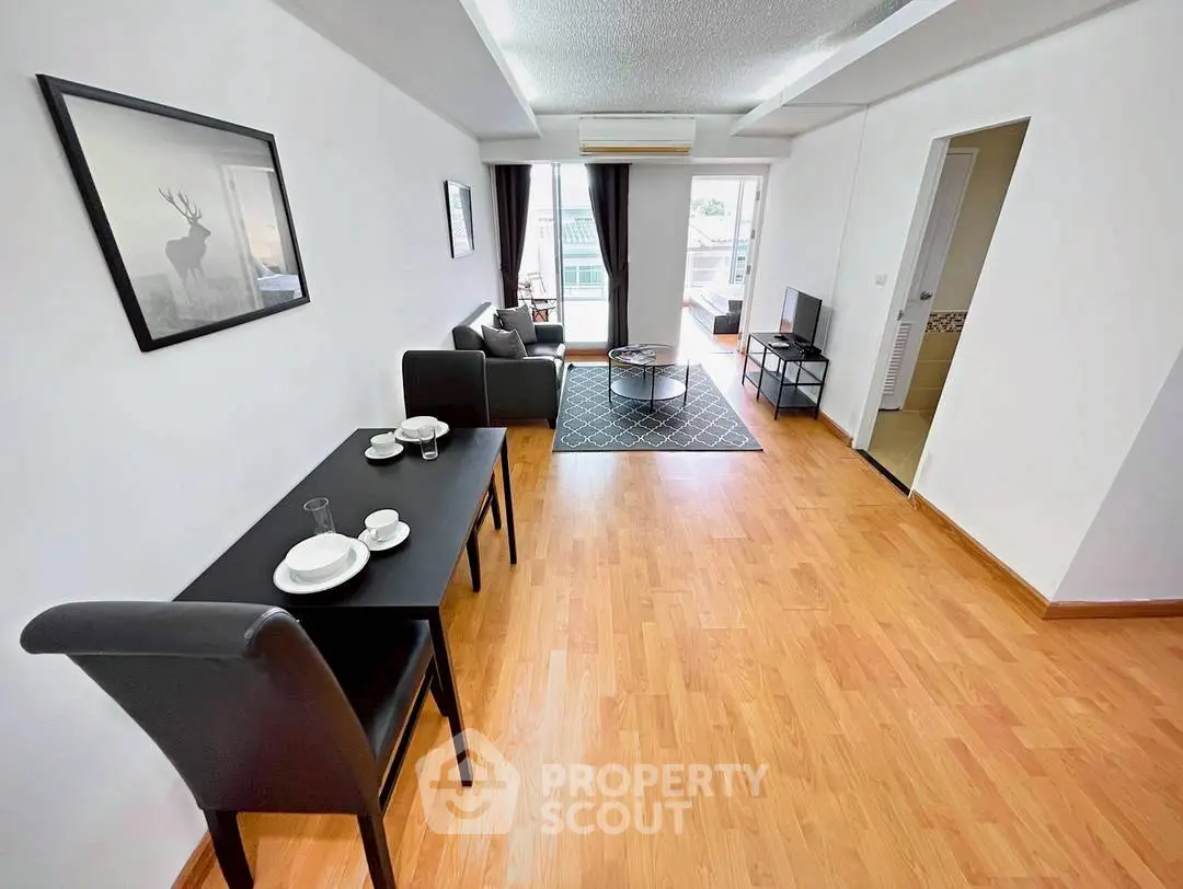Spacious living room with modern decor and balcony access in a stylish apartment.