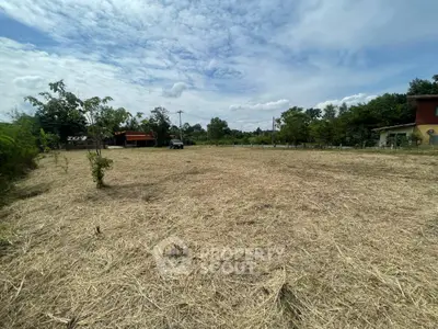 Expansive vacant land with potential for development, surrounded by lush greenery and open skies.