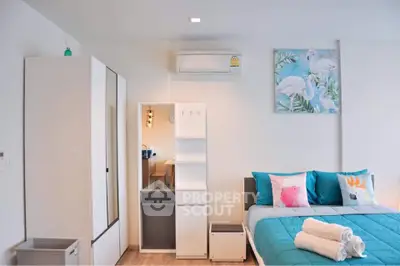 Modern bedroom with stylish decor, featuring a comfortable bed, wardrobe, and air conditioning unit.