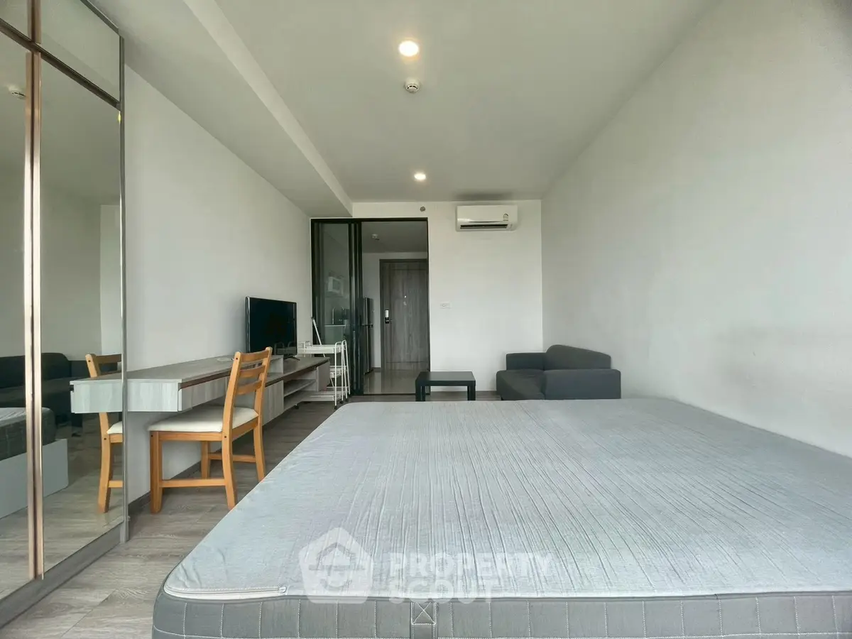 Spacious modern living room with minimalist decor and large window for natural light.