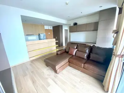 Spacious living room with modern open kitchen and cozy leather sofa