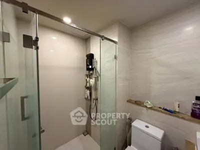 Modern bathroom with glass shower enclosure and sleek fixtures