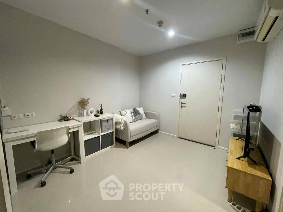 Modern minimalist study room with desk, chair, and sofa in a bright interior.