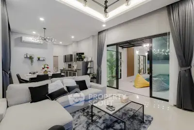 Modern open-plan living room with stylish decor and access to outdoor patio.