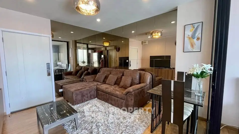 Luxurious living room with plush brown sofa, mirrored wall, and elegant decor in modern apartment.