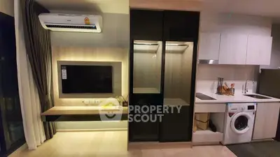 Modern apartment interior with sleek kitchen and living area featuring built-in appliances and stylish decor.