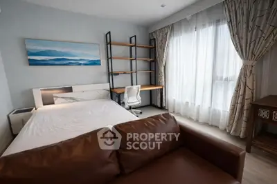 Modern bedroom with stylish decor and natural light, featuring a cozy bed and a functional study area.