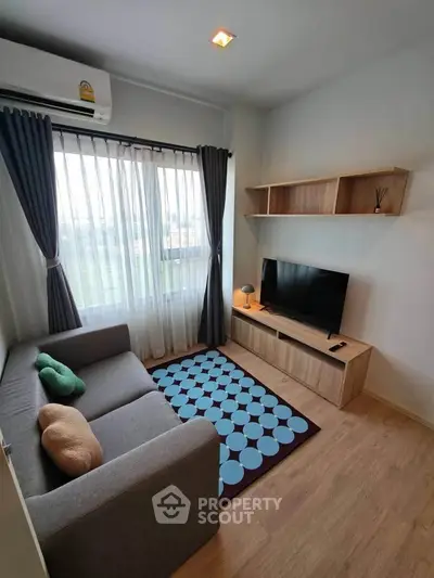 Cozy living room with modern decor, featuring a comfortable sofa, stylish TV stand, and large window with curtains.