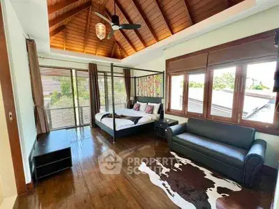 Luxurious bedroom with wooden ceiling and large windows offering natural light and scenic views.
