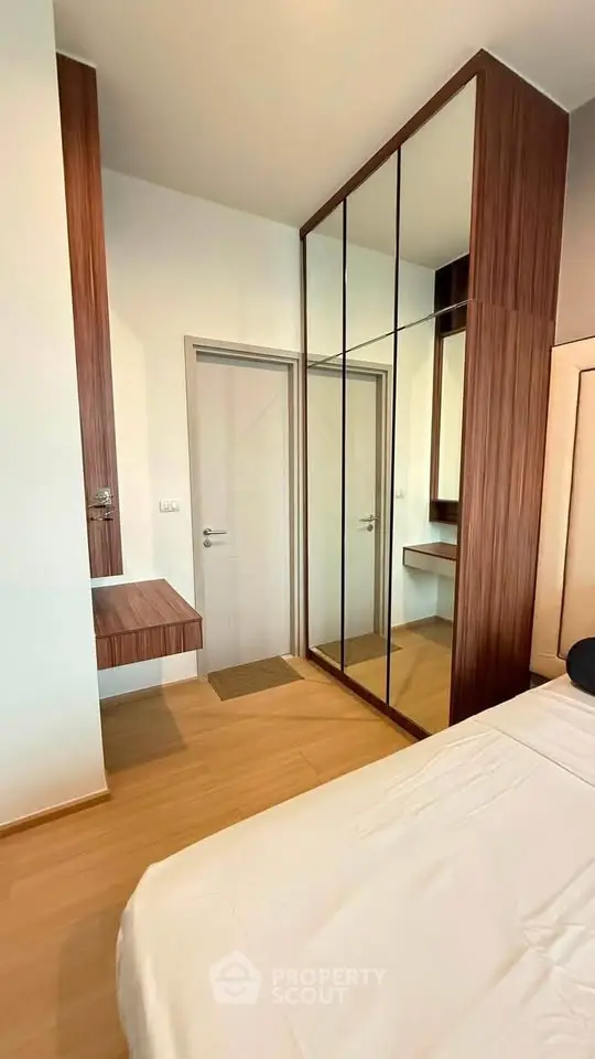 Modern bedroom with mirrored wardrobe and wooden accents