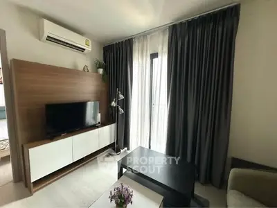 Modern living room with sleek furniture and natural light from large window.