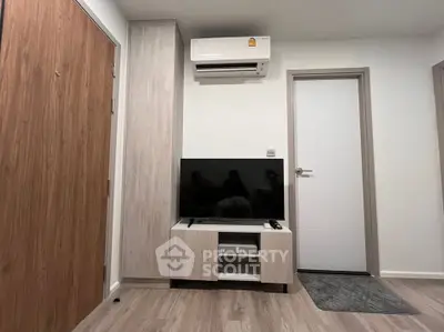 Modern living room with sleek TV setup and air conditioning unit