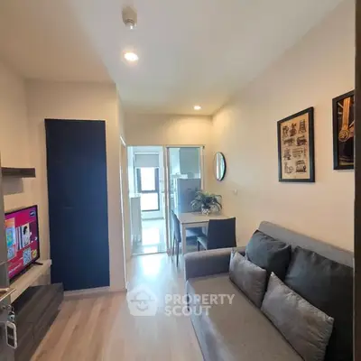 Modern living room with cozy sofa and dining area in a compact apartment.