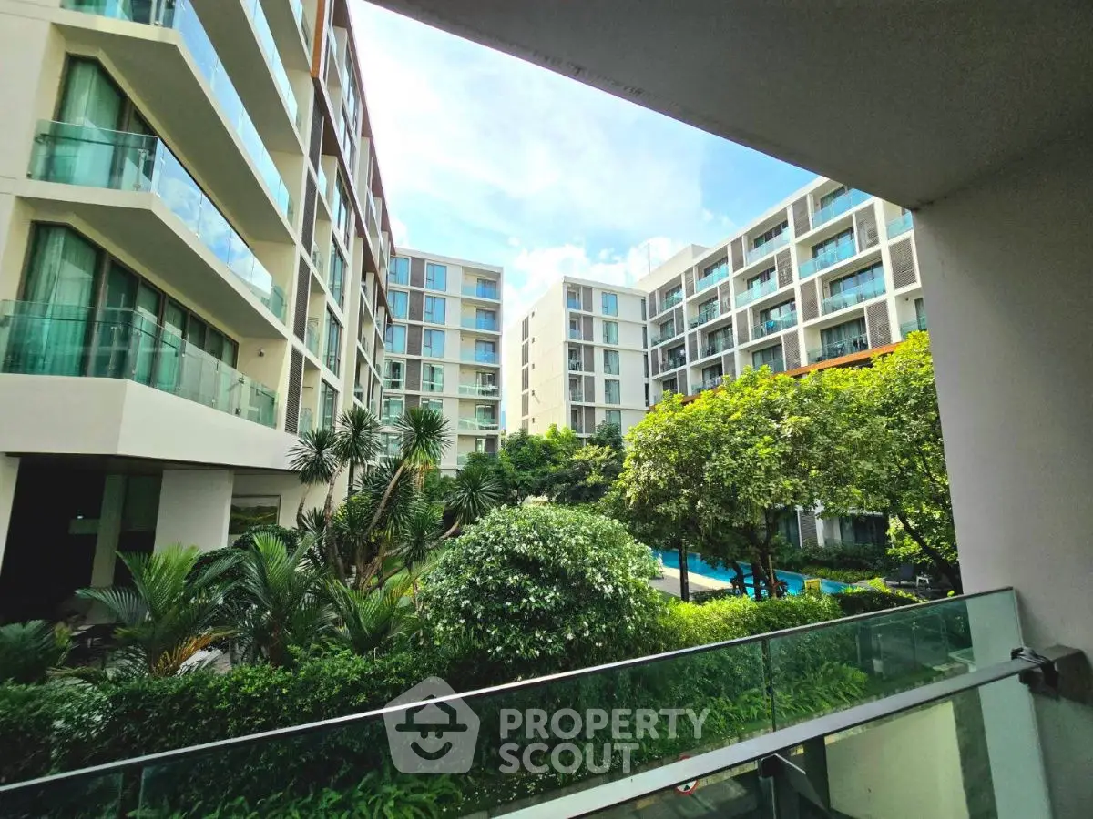 Modern apartment complex with lush garden and pool view