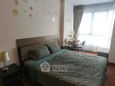 Elegant bedroom with stylish decor and natural light, featuring a cozy bed and a work desk by the window.