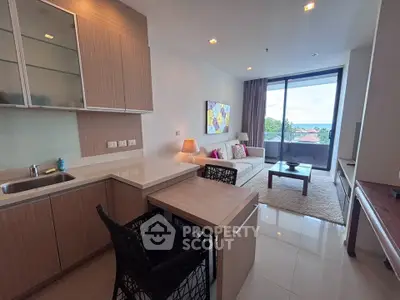 Modern open-layout living room with kitchen, featuring stylish decor and a scenic balcony view.