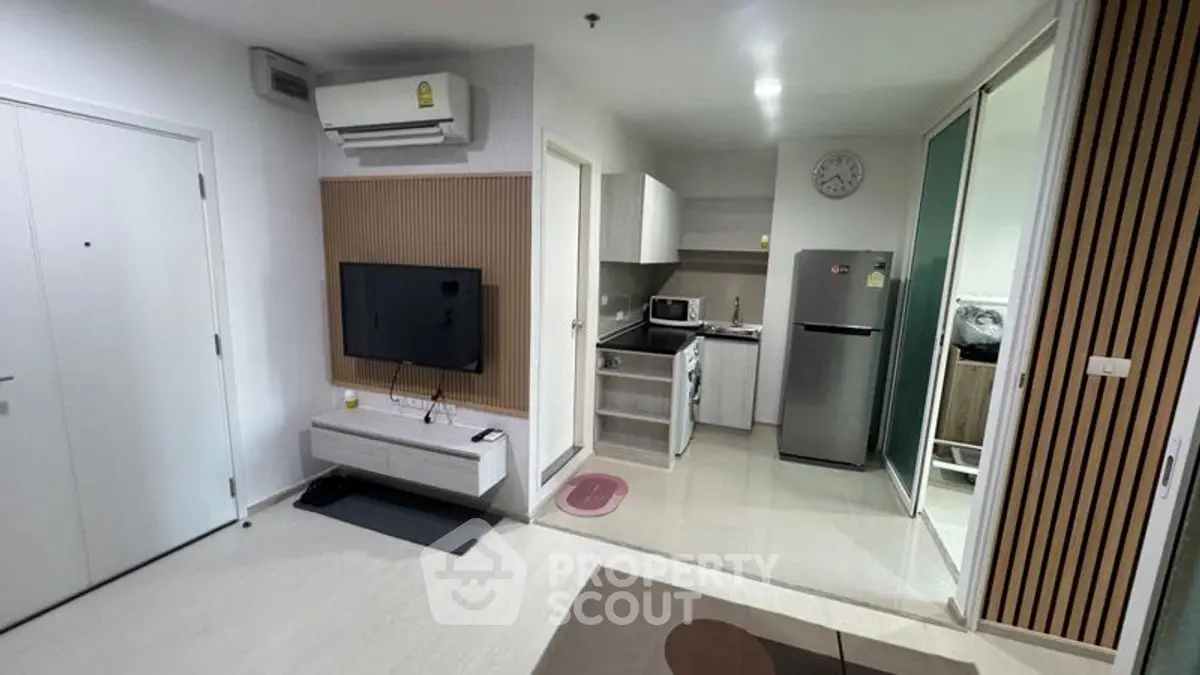 Modern apartment interior with open kitchen and living area, featuring sleek appliances and stylish decor.