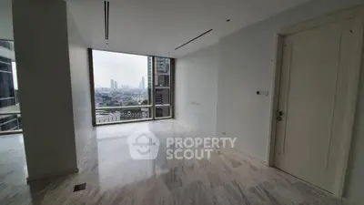 Spacious modern living room with large window offering stunning city view in luxury apartment.