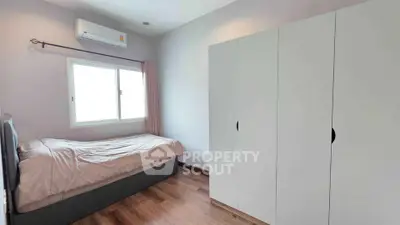 Cozy bedroom with modern wardrobe and air conditioning, perfect for a comfortable living experience.