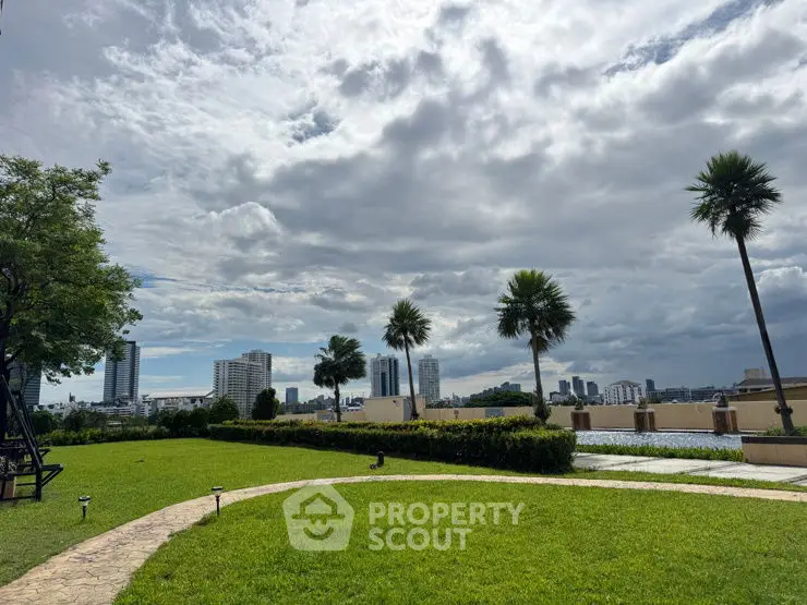 Stunning cityscape view from a lush green garden with palm trees and skyline backdrop.