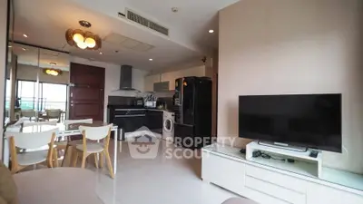 Modern open-plan living room with kitchen, featuring sleek appliances and stylish decor.