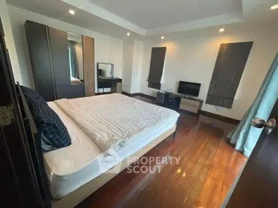 Spacious bedroom with modern furnishings and wooden flooring, ideal for comfort and relaxation.
