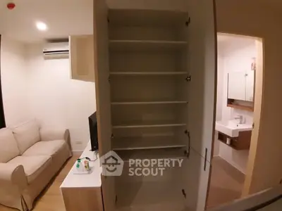 Modern apartment interior with open storage, cozy living area, and sleek bathroom design.