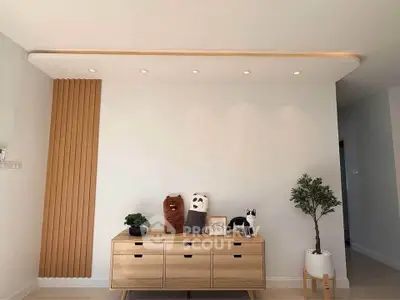 Modern living room with stylish wooden cabinet and decorative plants