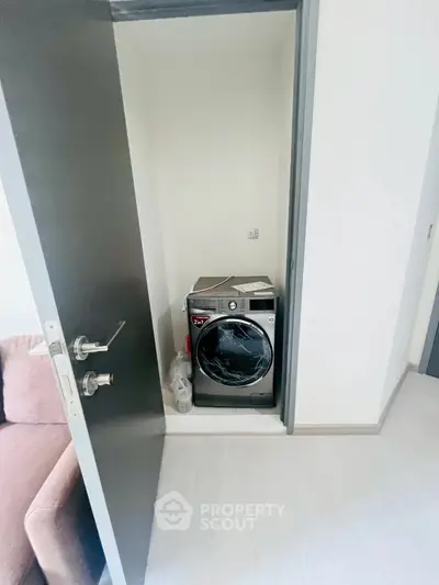 Compact laundry nook with modern washing machine in sleek apartment.