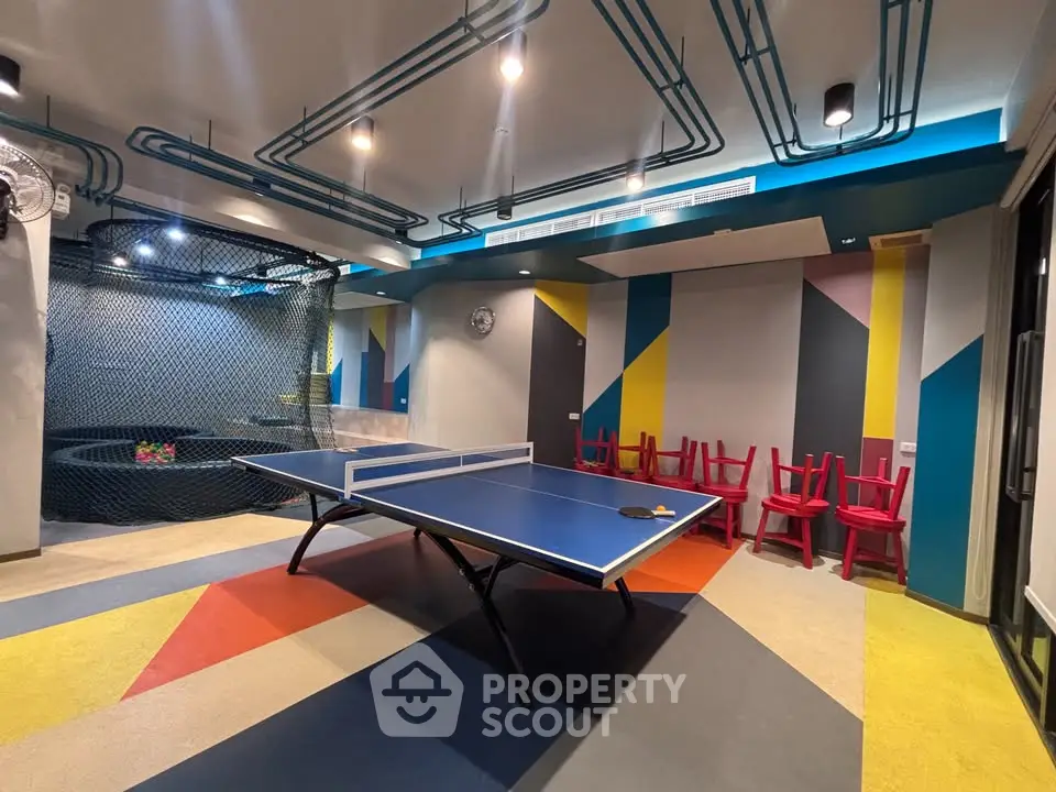Vibrant recreational room with ping pong table and colorful decor in modern building.
