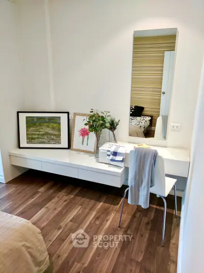 Chic bedroom corner with modern decor and wooden flooring, perfect for a cozy and stylish living space.